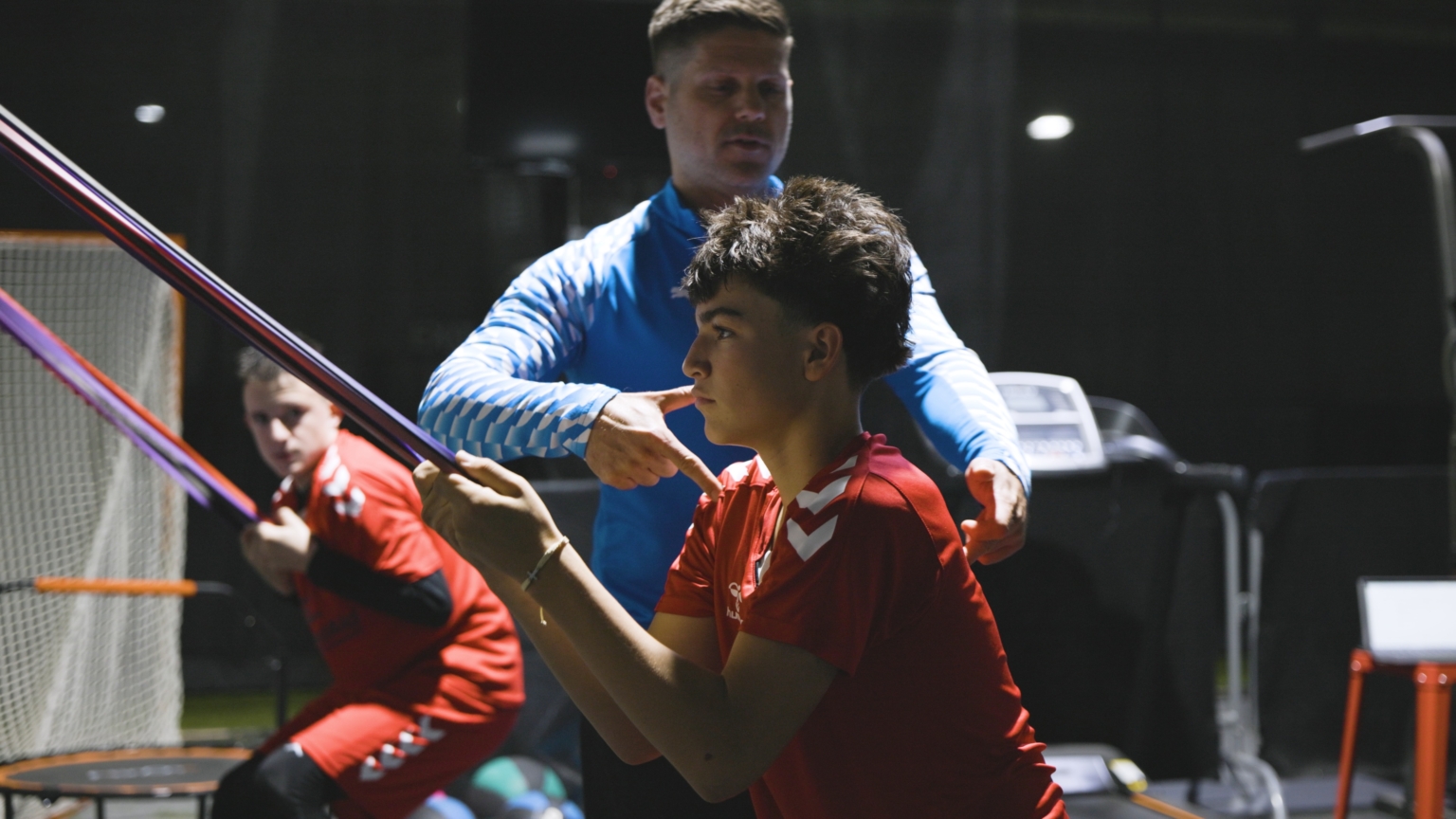 SFA performance coach guiding a youth player through resistance-band strength work in Columbus, Ohio